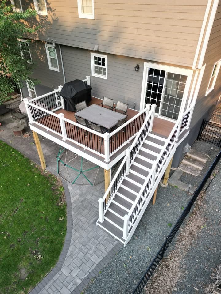 Elevated deck with white railing, paver walkway and grill