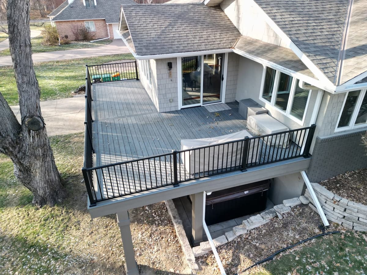 Completed deck project by House of Decks featuring a sunroom and full yard view