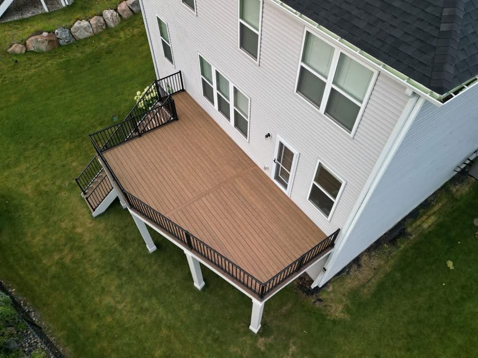 Tan composite deck with black railing and white posts