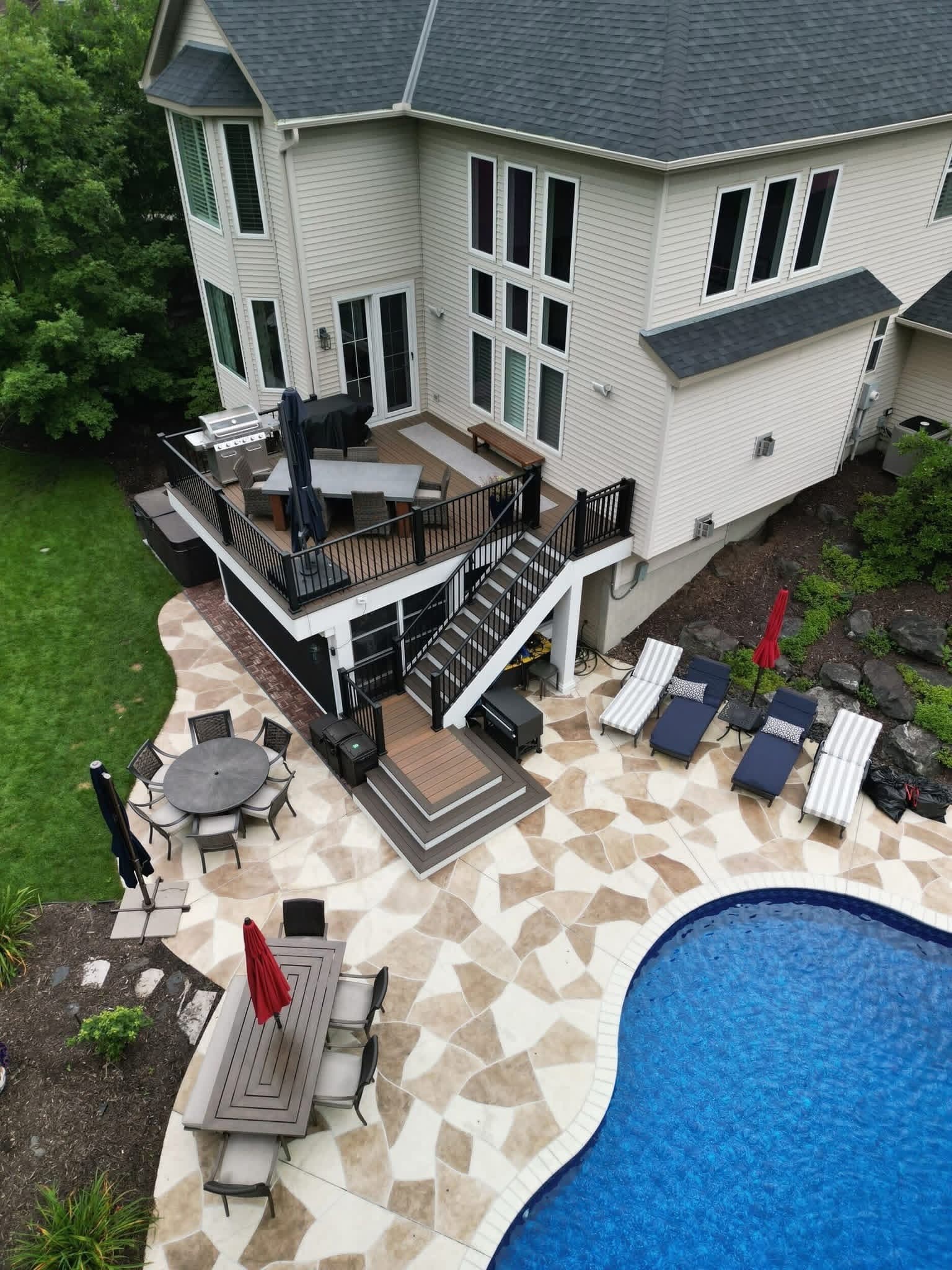 Multi-level deck with a pool, patio and lounge chairs